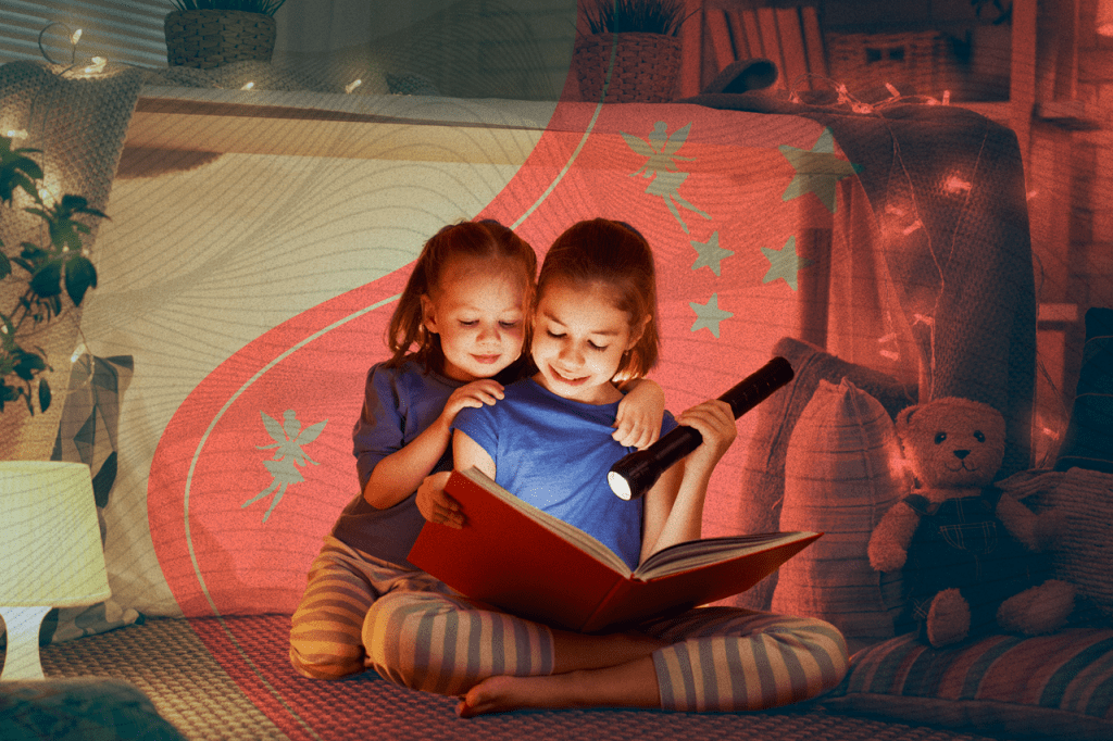 Livro Infantil - Duas crianças sentadas lendo um livro infantil com uma lanterna na mão