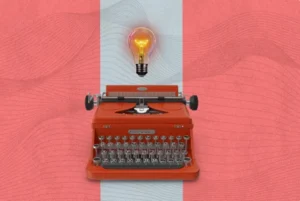 copywriting - na imagem há uma máquina de escrever vermelha abaixo de uma lâmpada acesa